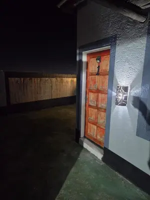 a door on the side of a building at night at Mantsho Lagoon