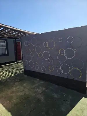 a wall with circles painted on the side of a building at Mantsho Lagoon