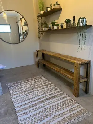 a room with a wooden bench and a mirror at Home with Thelana in Marloth Park