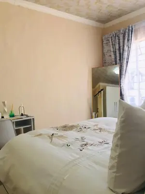 a white bed in a bedroom with a window at Blanc and Bold in Vosburg