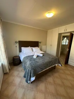 a bedroom with a bed with two towels on it at Klaverton Daisy in Benoni
