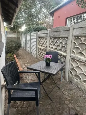 a picnic table and two chairs with a potted plant on it at Klaverton Daisy in Benoni