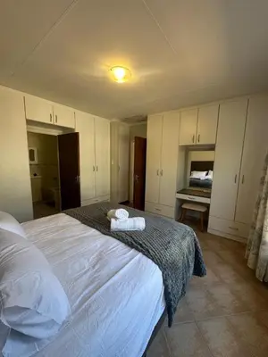 a bedroom with a large bed with towels on it at Klaverton Daisy in Benoni