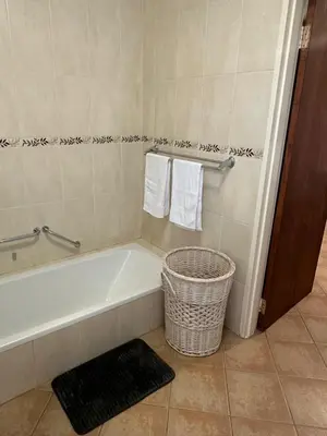a bathroom with a tub and a basket and towels at Klaverton Daisy in Benoni