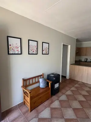 a living room with a bench and a kitchen at Klaverton Daisy in Benoni