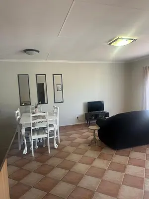 a living room with a table and a couch at Klaverton Daisy in Benoni