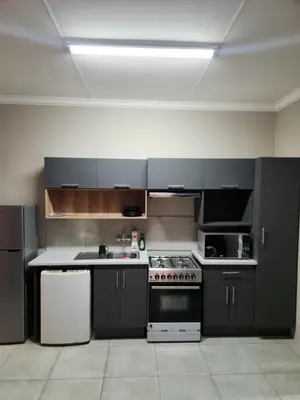 a kitchen with black cabinets and a white stove at Secret pillow in Trichardt