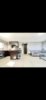 a living room with a kitchen and a stove at Villa on hope in Midrand