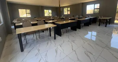a restaurant with tables and chairs in a room at Glowti Event & Guest House in Centurion