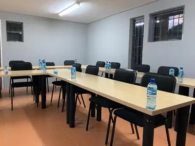 a room with tables and chairs with water bottles on them at Glowti Event & Guest House in Centurion