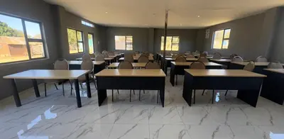 a dining room with tables and chairs and windows at Glowti Event & Guest House in Centurion