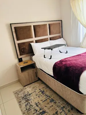 a bedroom with a bed with a bench on it at Dubai guest house in Soshanguve