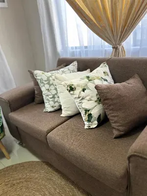 a couch with pillows on it in a living room at Dubai guest house in Soshanguve