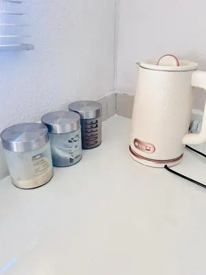a coffee maker and four containers on a counter at Dubai guest house in Soshanguve