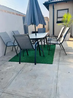 a table and chairs with an umbrella on a patio at Dubai guest house in Soshanguve