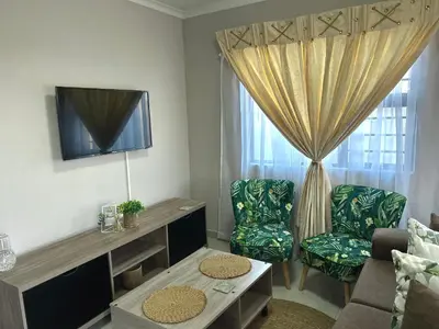 a living room with a couch and a tv and a window at Dubai guest house in Soshanguve