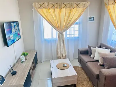 a living room with a couch and a table at Dubai guest house in Soshanguve