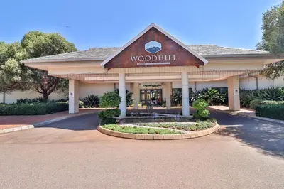 a building with a sign that reads woodland hill at Big 5 Cottage in Pretoria