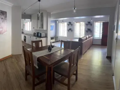 a kitchen and dining room with a table and chairs at Big 5 Cottage in Pretoria