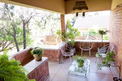 an outdoor patio with chairs and plants on it at Luisa's Place in Pretoria