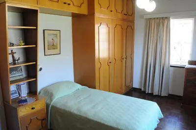 a bedroom with a bed and wooden cabinets and a window at Luisa's Place in Pretoria