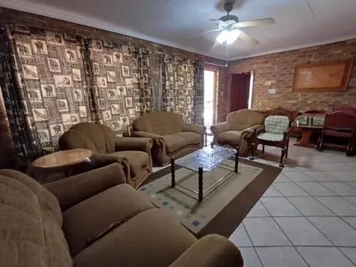 a living room with couches and chairs and a table at IFAFA732 Akkommodasie in Leeupoort