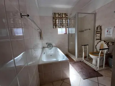 a bathroom with a tub and a shower and a toilet at IFAFA732 Akkommodasie in Leeupoort