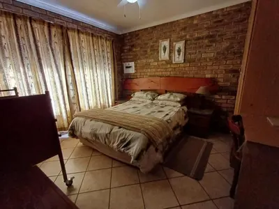 a bedroom with a bed and a brick wall at IFAFA732 Akkommodasie in Leeupoort