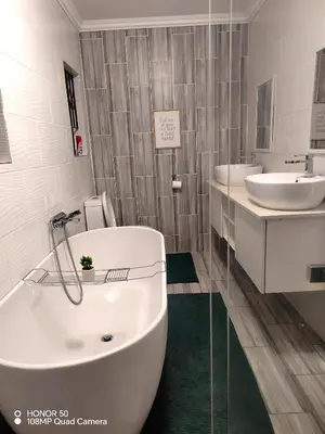 a bathroom with two sinks and a bath tub at Palma Royal Ensuite in Pretoria