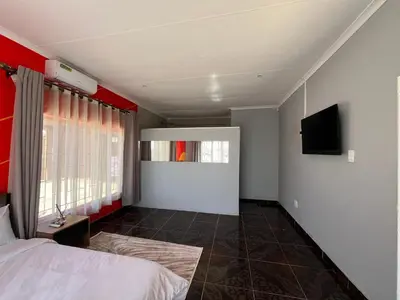 a bedroom with a bed and a flat screen tv at 419 Guest House in Midrand
