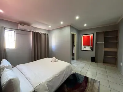 a bedroom with a white bed and a tv at 419 Guest House in Midrand