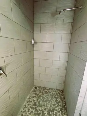 a bathroom with a shower with white tiles at Letamo View - 5 bedroom house in Hartbeespoort
