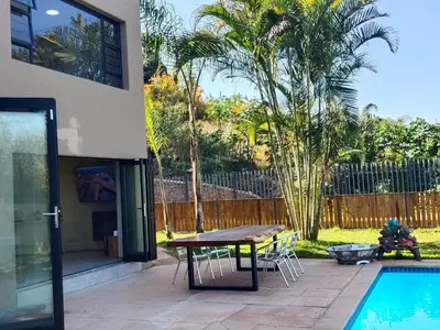 a patio with a table and chairs next to a pool at Letamo View - 5 bedroom house in Hartbeespoort