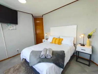 a bedroom with a bed with two slippers on it at Letamo View - 5 bedroom house in Hartbeespoort