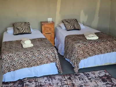 a room with two beds with towels on them at Dongodzi Lodge in Ha-Lambani