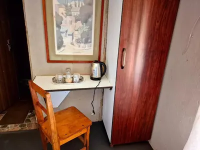 a desk with a sink and a wooden chair at Dongodzi Lodge in Ha-Lambani