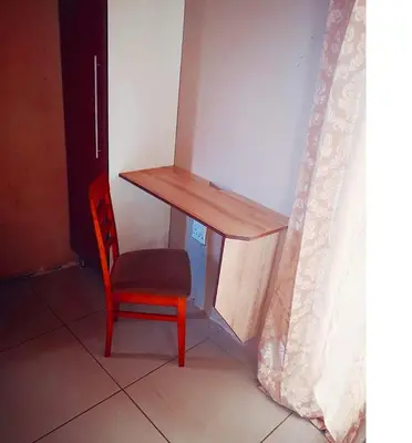 a desk and a red chair next to a wall at Dongodzi Lodge in Ha-Lambani