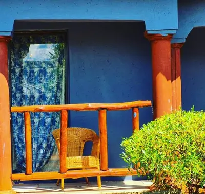 a wicker chair sitting on the front porch of a house at Dongodzi Lodge in Ha-Lambani