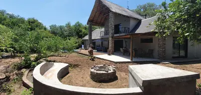 a man standing in a yard in front of a house at Leadwood Marloth Lodge in Marloth Park