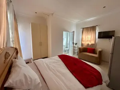 a bedroom with a bed with a red and white blanket at The Homestead on Nutmeg in Pretoria
