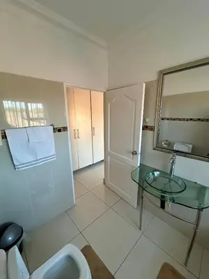 a bathroom with a glass table and a sink at The Homestead on Nutmeg in Pretoria