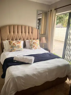a large bed with a large headboard in a bedroom at 17 Byvanger Luxury Home Deluxe Queen Suite Room 2 in Centurion