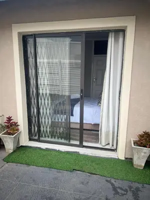 a sliding glass door to a bedroom with a bed at 17 Byvanger Luxury Home Deluxe Queen Suite Room 2 in Centurion