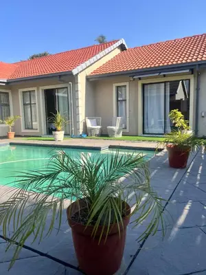 a house with potted plants next to a swimming pool at 17 Byvanger Luxury Home Deluxe Queen Suite Room 2 in Centurion