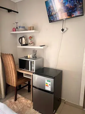 a kitchen with a microwave and a table with a chair at 17 Byvanger Luxury Home Deluxe Queen Suite Room 2 in Centurion