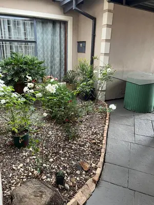 a garden with flowers and plants in front of a building at 17 Byvanger Luxury Home Deluxe Queen Suite Room 2 in Centurion