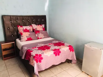 a bedroom with a bed with a pink comforter at Joyx BNB in Sibayeni