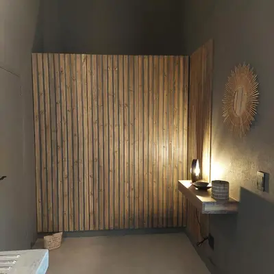 a room with a large wooden wall with a desk at Bush Serenity Studio in Marloth Park