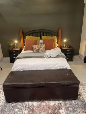 a large bed in a bedroom with two night stands at Seven in Secunda