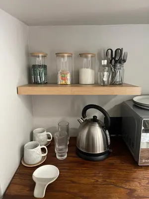 a kitchen counter with a tea kettle and cups on a shelf at Seven in Secunda